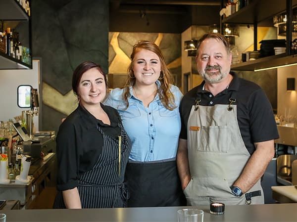 Completed restaurant build by Jeff Smith Construction in Folsom. Restaurant staff working inside a finished dining space constructed by Jeff Smith Construction in Folsom, CA.
