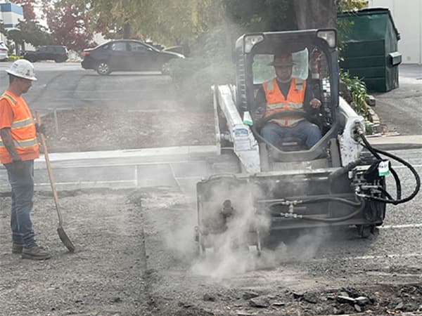 Heavy equipment operator at Jeff Smith Construction in Sacramento. Jeff Smith Construction employee operating heavy machinery to break up pavement at a job site in Sacramento, CA.